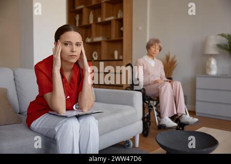 Upset frustrated doctor holding head leaned over patient card Stock Photo