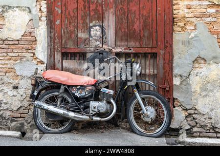 Boy on Motorbike street art mural by Lithuanian artist Ernest Zacharevic in George Town, Penang, Malaysia. Stock Photo