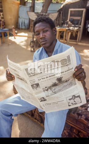 Niger, Niamey, man reads the newspaper "Le Sahel". Stock Photo
