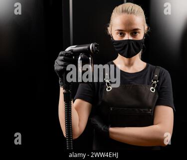 The master of instant tanning holds a spray pen with lotion. Express tan in a beauty salon. Stock Photo