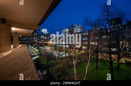 London, UK: Night view of the Barbican Estate in the City of London with garden and lake. A prominent example of Brutalist architecture. Stock Photo