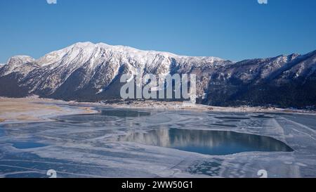 Aerial view of the glacial lake Blidinje in Bosnia and Herzegovina. Frozen Lake with mountains covered with snow in the background. Stock Photo