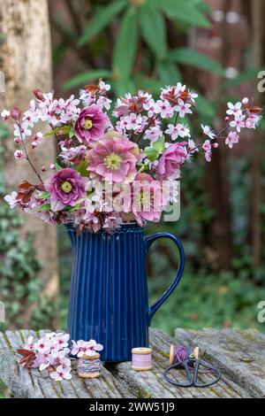 bouquet of pink lenten roses and purple-leaf plum blossom in a vase Stock Photo