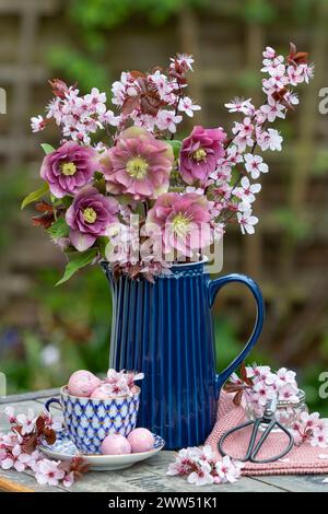 bouquet of pink lenten roses and purple-leaf plum blossom in a vase Stock Photo