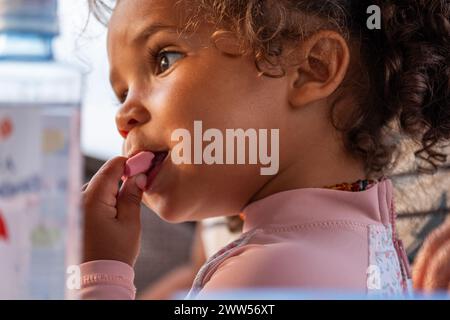 Innocence and curiosity blend on the face of a mixed-race toddler, their thoughtful eyes reflecting a quiet moment of Stock Photo