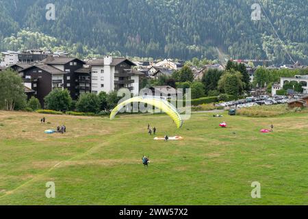 High-angle view of paragliders on the meadow landing point near the centre of the alpine town in summer, Chamonix, Haute Savoie, France Stock Photo