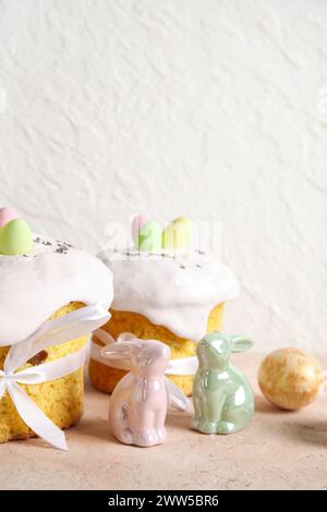 Composition with delicious Easter cakes, porcelain bunnies and painted eggs on color background Stock Photo