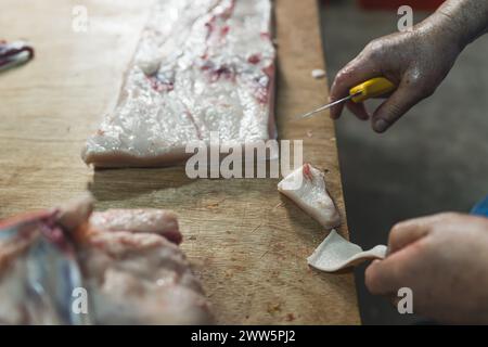 Close up of butchers hands slicing raw steak on butchers block. High quality photo Stock Photo