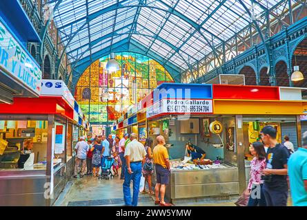 MALAGA, SPAIN - SEPT 28, 2019: People walk in fish section of Atarazanas central market, choosing fresh fish and seafood on ice, on Sept 28 in Malaga Stock Photo