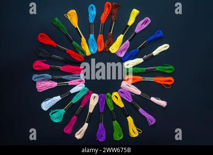 Many skeins of mouline thread for embroidery on a row in circle on black background Stock Photo