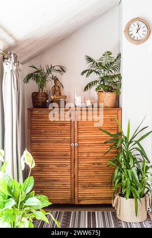 wooden chest of drawers with decorations and flowers in the interior Stock Photo