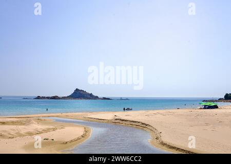Goseong County, South Korea - July 30, 2019: A freshwater stream gracefully cuts through the sandy shores of Sampo Beach, flowing into the East Sea, w Stock Photo