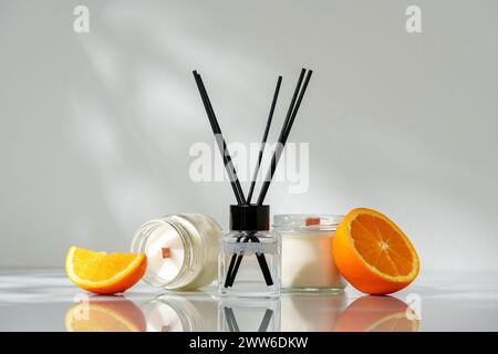 Elegant Aroma Diffuser With Black Reeds on a Slate Base Next to a Fresh Orange Slice Stock Photo