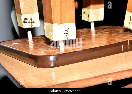 The photo shows a close-up of the moment when the chair seat is connected to the chair legs using wooden dowels. Stock Photo