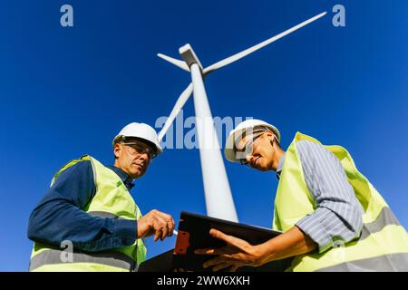 Electrical engineer working on reports on a wind energy farm. Stock Photo