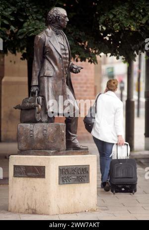 File photo dated 12/07/11 showing a traveler passing Thomas Cook statue outside Leicester railway station.   Travel group Thomas Cook has announced it Stock Photo