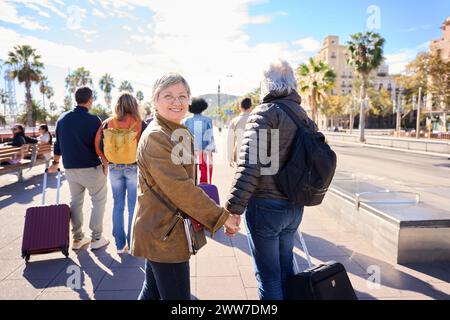 Happy husband and wife walking of the streets of the city on holidays. Mature tourist couple Stock Photo
