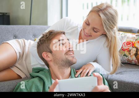 Couple on Sofa Using Smartphone Stock Photo
