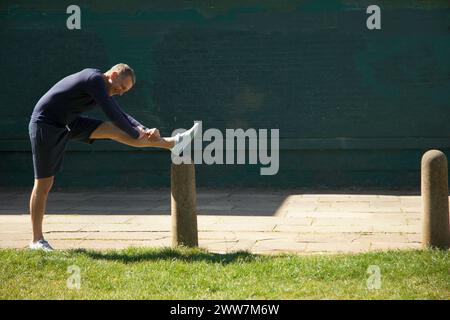 Mature Man Stretching Leg in the Park Stock Photo