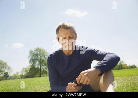 Close up of Mature Man Listening to Music on Smartphone Stock Photo
