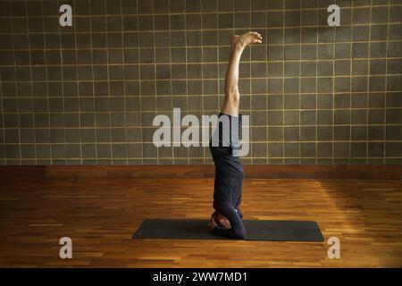 Mature Man Practicing Yoga, Headstand Stock Photo