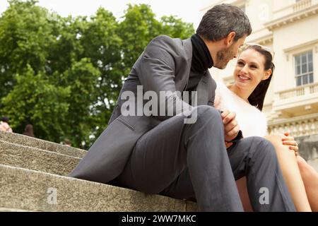 Couple Sitting on Steps Outdoors Stock Photo