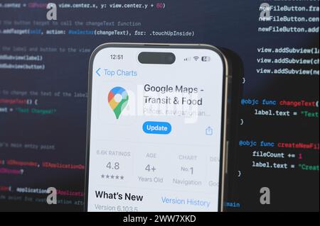 New York, USA - February 23, 2024: Google maps on iphone screen in blurred code programming background Stock Photo