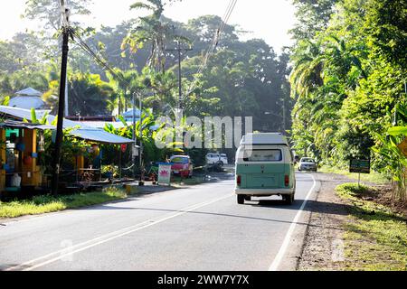 Tourists in old VW vintage campervan exploring Costa rica on a road trip, driving on a coastal road to Puerto Viejo on Caribbean coast, Costa rica Stock Photo