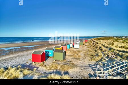 Findhorn Moray Coast Scotland row of colourful beach huts overlooking the sand beach and blue sea Stock Photo