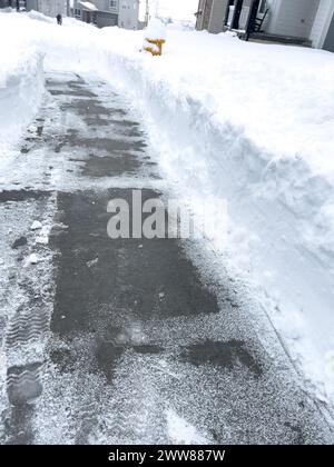 Cleared Pathway Amidst Snowy Suburban Landscape Stock Photo