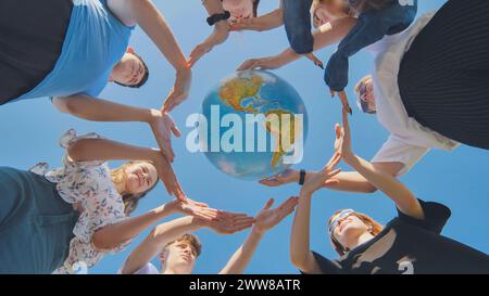 Young friends surround the globe of the world with their palms. The ...