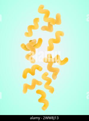 Raw cavatappi pasta falling on aquamarine background Stock Photo