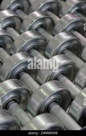 Steel conveyor rollers, close-up shot, abstract industrial background Stock Photo