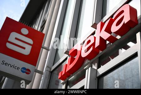 PRODUCTION - 22 March 2024, Hesse, Frankfurt/Main: The 'Deka' logo of DekaBank is emblazoned on the façade of the Trainon tower next to a savings bank logo at the bank's headquarters. On March 26, 2024, the Wertpapierhaus of the Sparkassen-Finanzgruppe presents the balance sheet for the past financial year 2023. Photo: Arne Dedert/dpa Stock Photo