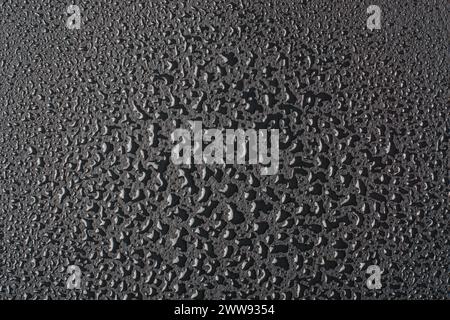 water droplets on black surface, abstract texture of wet drops condensation with reflective lights background wallpaper for graphic designing Stock Photo