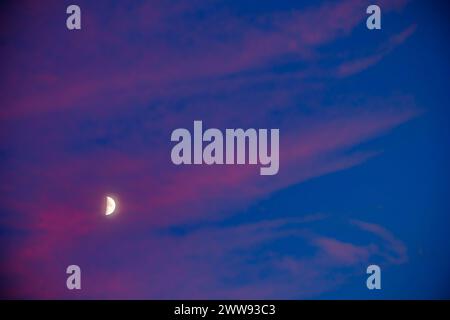 Moon at sunset between pink clouds in Alhambra Stock Photo