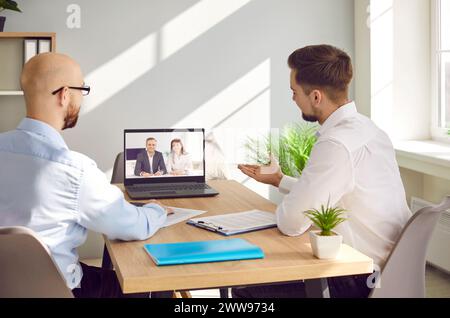 Team of remote colleagues having discussion during online business meeting via video call Stock Photo
