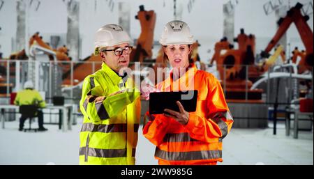 Workers In Automotive Car Factory Using Tablet Stock Photo