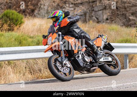 A man sits on his motorcycle and riding on a curving road, photograph taken on August 22, 2020 in the province of Avila, Spain, called the port of Nav Stock Photo