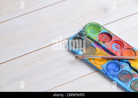 Rustic brush and watercolors close-up on a wooden work table. Perfect for artistic themes or painting concepts Stock Photo