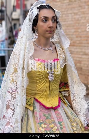 A Fallera’s golden corset and floral skirt embody the festival’s artistry. Her lace shawl whispers tales of Valencia’s timeless elegance. Stock Photo