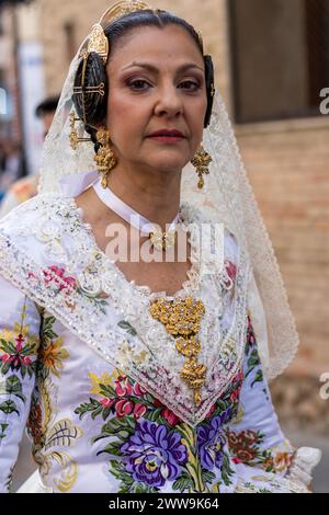 Valencian Elegance Unveiled; A Fallera’s floral embroidery and golden details reflect Gandia’s festive soul. Her lace veil and ornate necklace are the Stock Photo