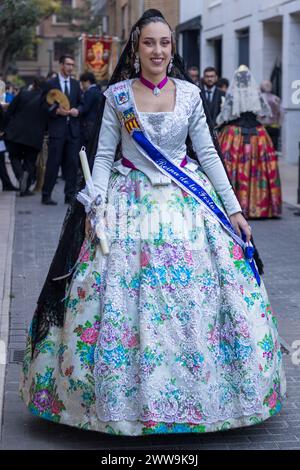 A woman in traditional Valencian dress captivates with her floral-patterned gown during the vibrant celebrations in Gandia. Her attire, a canvas of hi Stock Photo