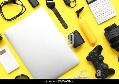 Composition with modern gadgets on yellow background Stock Photo