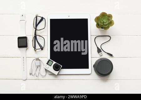 Composition with modern gadgets and eyeglasses on light wooden background Stock Photo