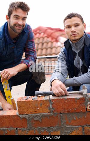 Building, bricklayer and working with industrial tools, maintenance employee with brick wall for renovation. Contractor, together on building project Stock Photo