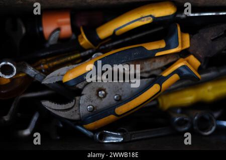 Box of Miscellaneous tools including screwdriver, pliers, spirit level in a jumble. All piled on top of each other. Close up of tools box. Stock Photo