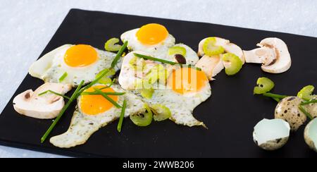 Broken fried quail eggs with mushrooms Stock Photo