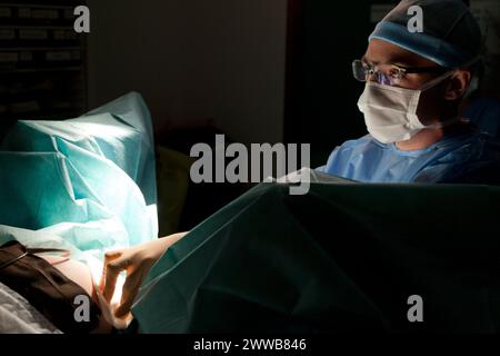 Once the cervix is open comes the moment of birth. In a few pushes the child will be born. Midwife - man helping the parturient to give birth. Stock Photo