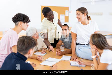 Multiracial mixed age group participating adult education class with African American tutor Stock Photo